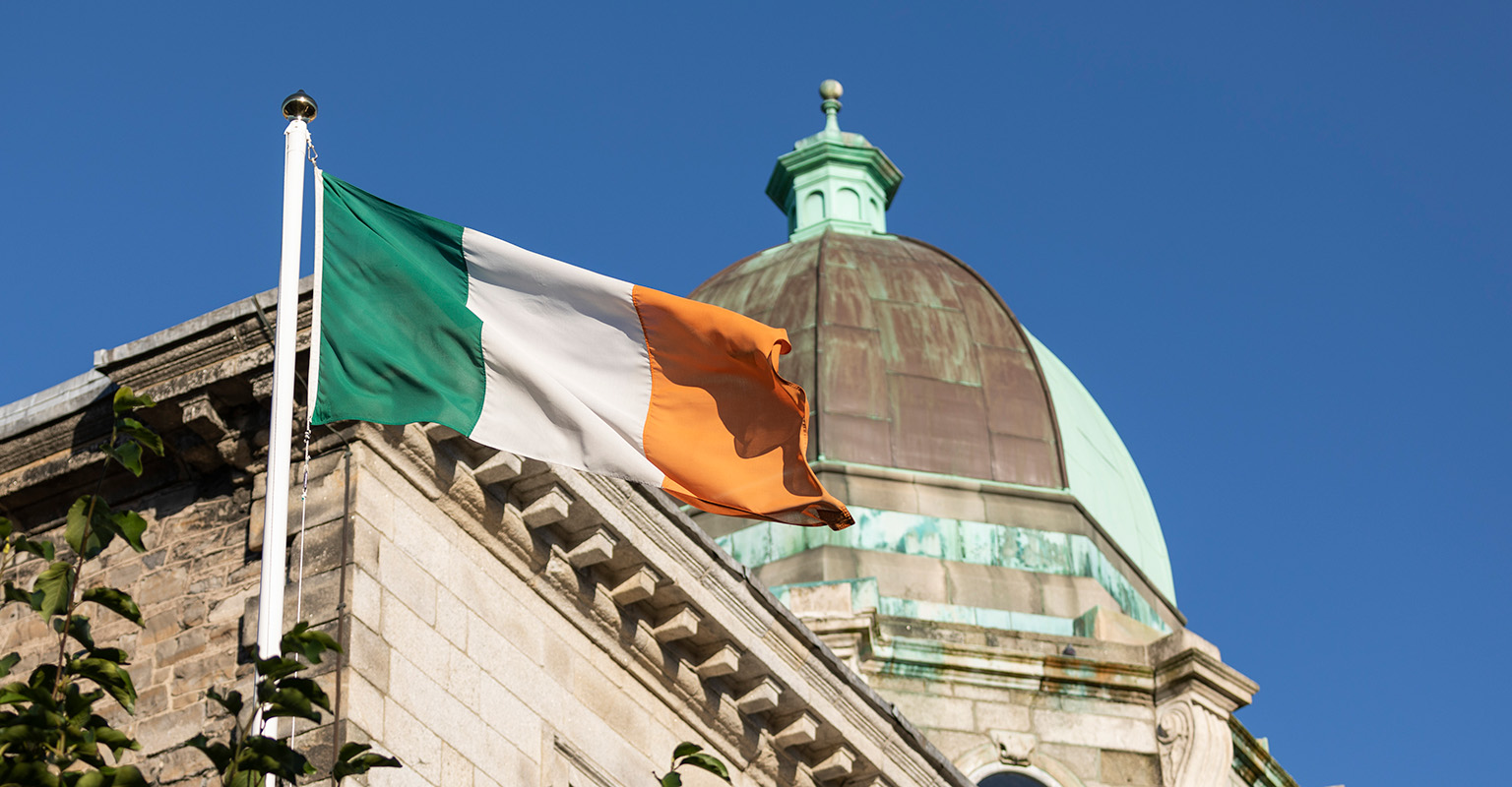 The Irish flag at Blackhall Place with a classical building cupola in the background