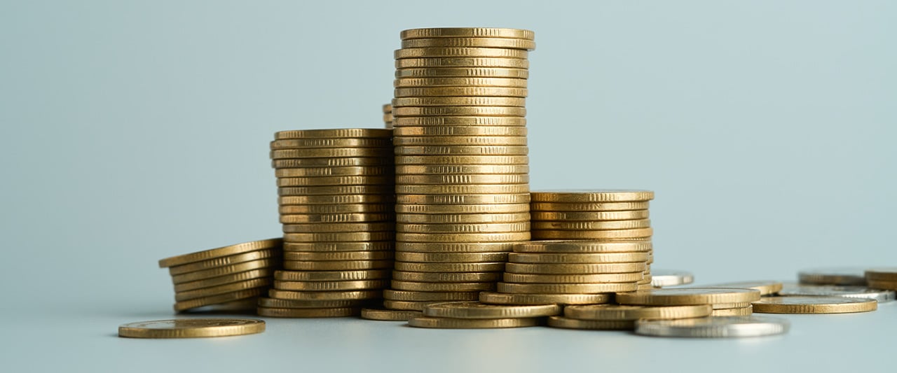 A stack of coins against a teal background