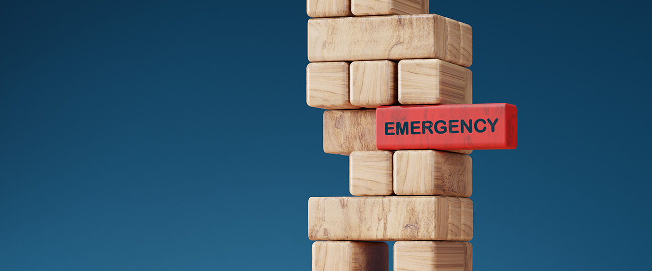 Wooden blocks resting on a red block marked 'emergency'