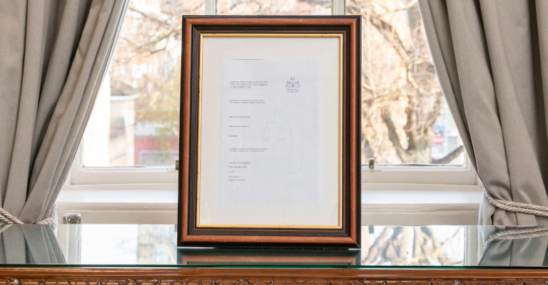 A practising certificate sitting on a solicitors' desk
